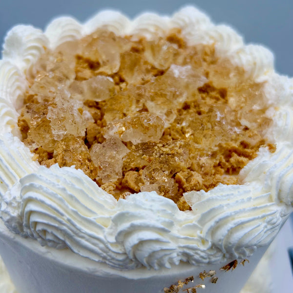 detalle superior de pastel de cava y turron con crema y virutas doradas