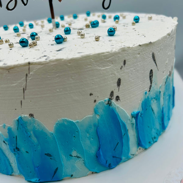 Detalle lateral de tarta azul y plata con chantilly