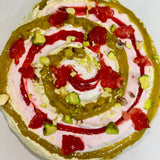Corte interior de la tarta de pistacho y frambuesa con relleno cremoso y coulis artesanal