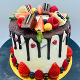 Pastel drip cake con fruta y chocolatinas