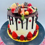 Pastel drip cake con fruta y chocolatinas