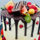 Pastel drip cake con fruta y chocolatinas