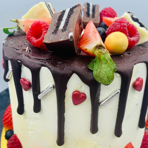 Pastel drip cake con fruta y chocolatinas