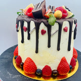 Pastel drip cake con fruta y chocolatinas