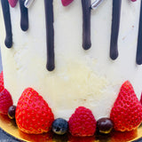 Pastel drip cake con fruta y chocolatinas