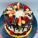 Pastel drip cake con fruta y chocolatinas