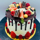 Pastel drip cake con fruta y chocolatinas